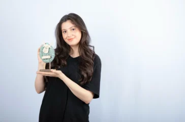 Ilustrasi wanita asia mempelihatkan tabungannya sebagai bentuk melek investasi.