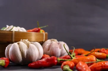 Gambar yang menunjukkan bawang putih dan cabai merah yang harganya sedang naik karena inflasi